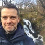 Man with waterfall as a backdrop