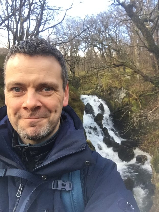 Man with waterfall as a backdrop