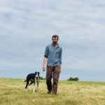 Man walking with dog across field