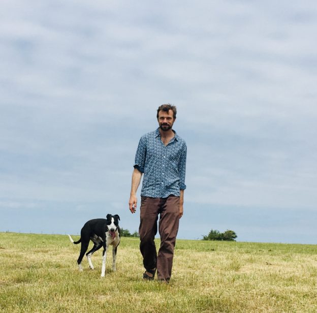 Man walking with dog across field